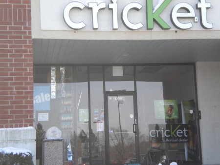 A photo of a front entrance to a Cricket store for cell phones.