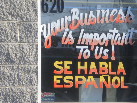 A business promoting their good customer service with a sign saying Spanish Spoken Here.